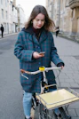 woman in red and black checkered coat and blue denim jeans holding yellow and black bicycle