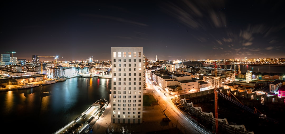 city buildings near body of water during night time