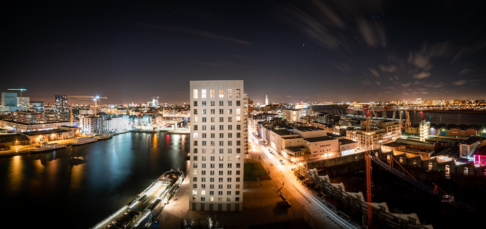 city buildings near body of water during night time