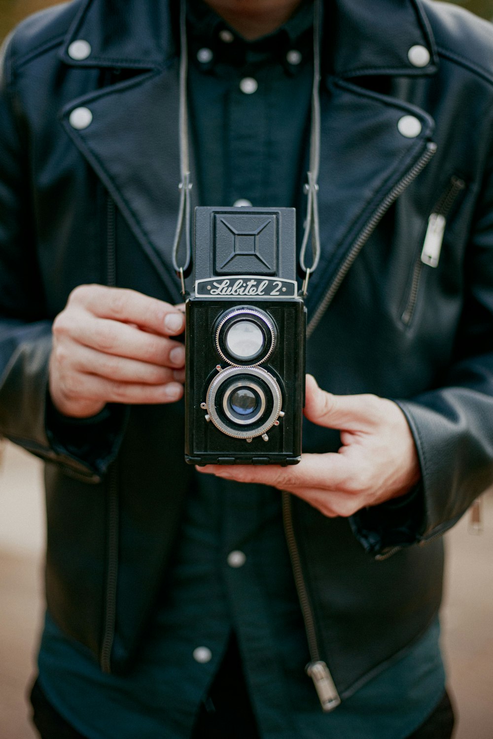 person holding black and silver camera