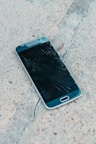 black samsung android smartphone on gray concrete floor