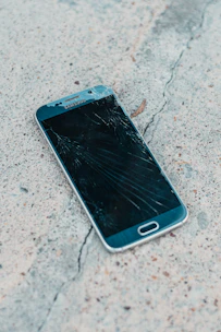 A sleek smartphone with a cracked screen, recently sold and ready for its new owner.