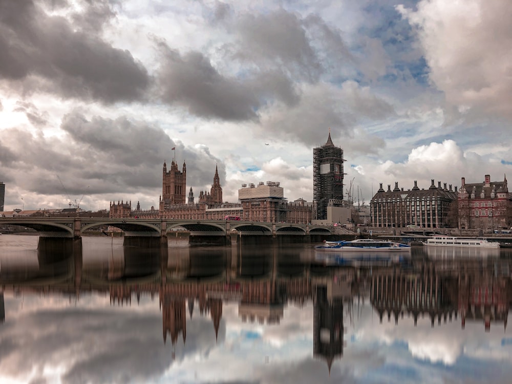 brown concrete building near body of water under cloudy sky during daytime