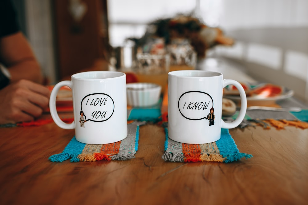 white and brown ceramic mug on blue and white textile