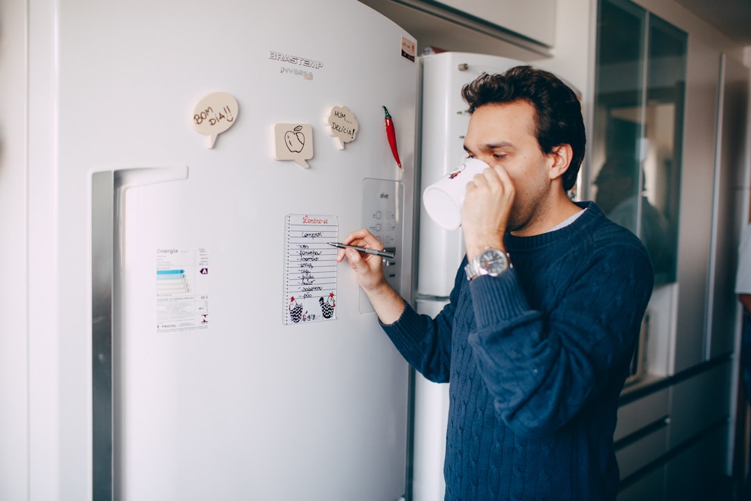 man in blue sweater drinking from white ceramic mug