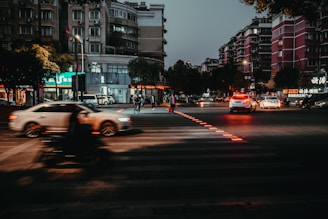 A close-up of a city street intersection at dusk, highlighting the contrast between business buildings and everyday life.