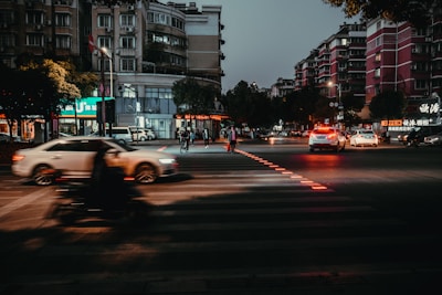 A close-up of a city street intersection at dusk, highlighting the contrast between business buildings and everyday life.