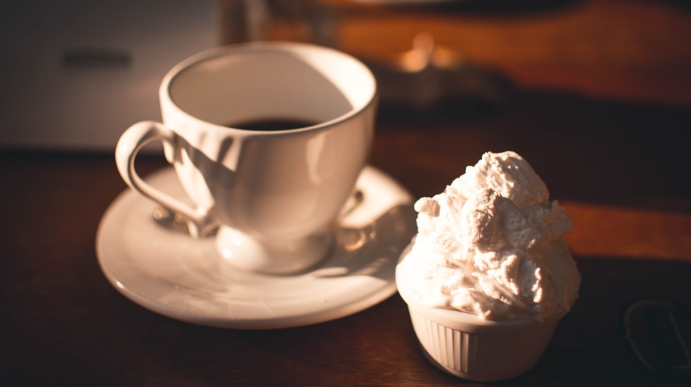 taza de cerámica blanca sobre platillo de cerámica blanca