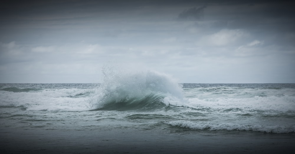 ocean waves crashing on shore during daytime