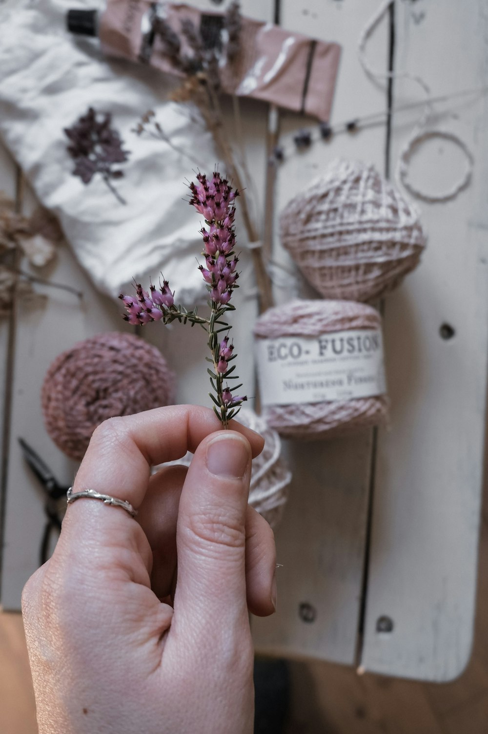 person holding pink and white yarn