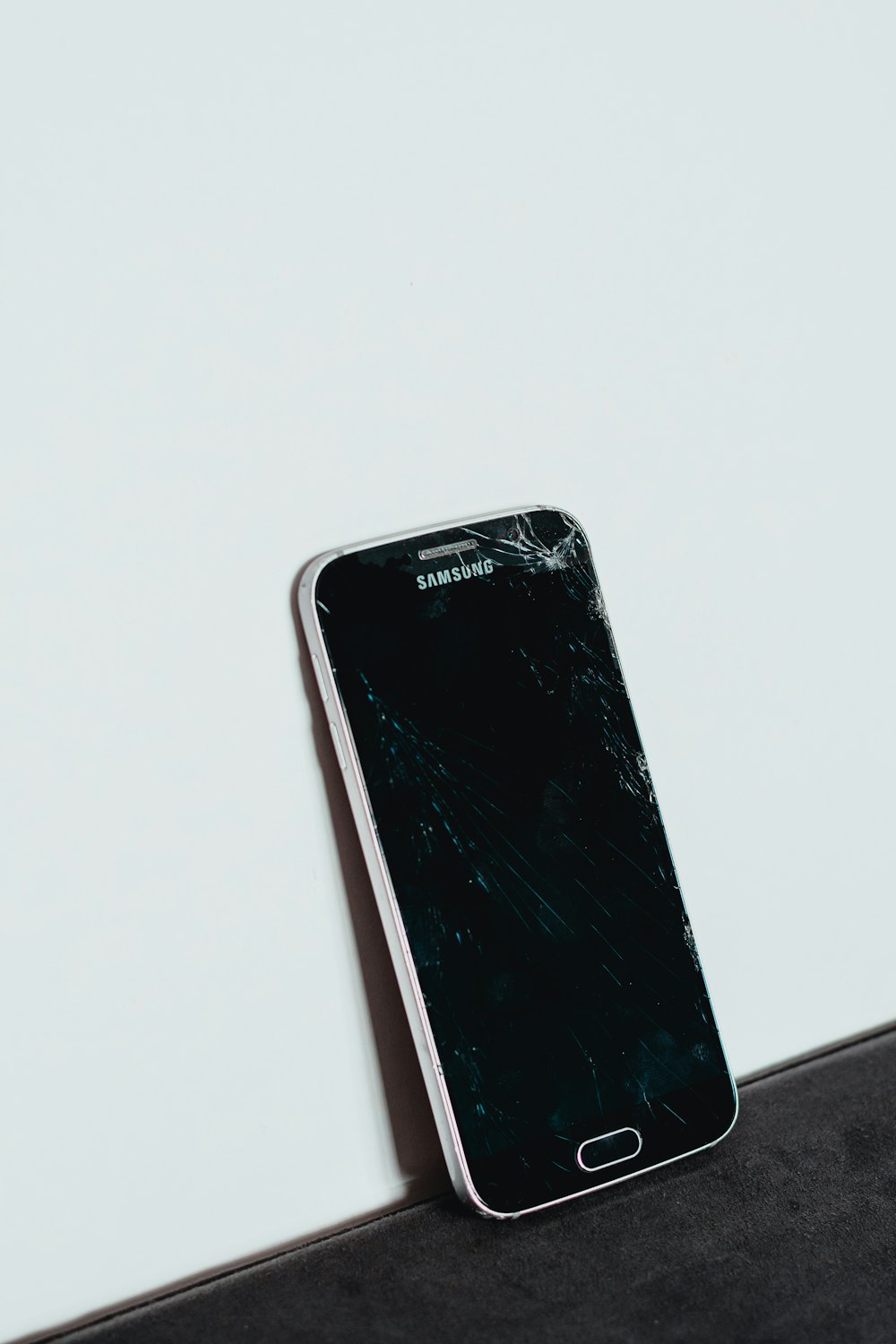 Teléfono inteligente Samsung Android negro sobre mesa blanca
