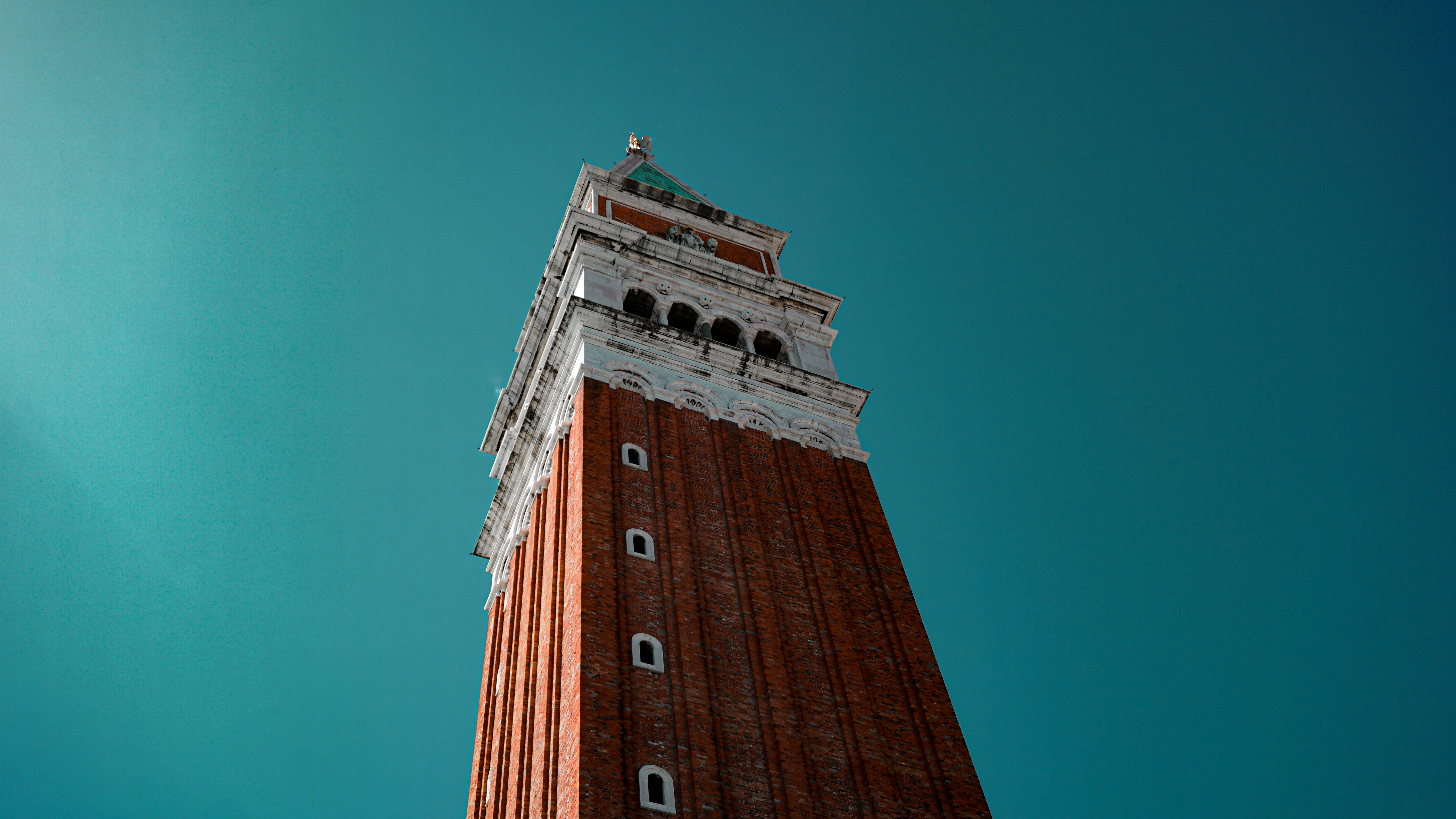 brown brick tower under blue sky