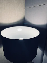 Close-up of a sleek black acrylic lamp glowing softly with warm gold accents.