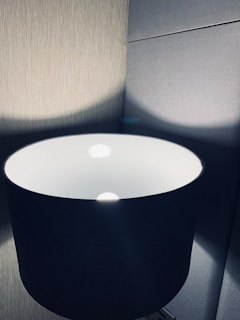 Close-up of a stylish lamp casting gentle shadows on a textured wall.