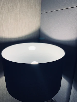 Close-up of a soft purple glowing artistic lamp casting intricate shadows on matte black surfaces.