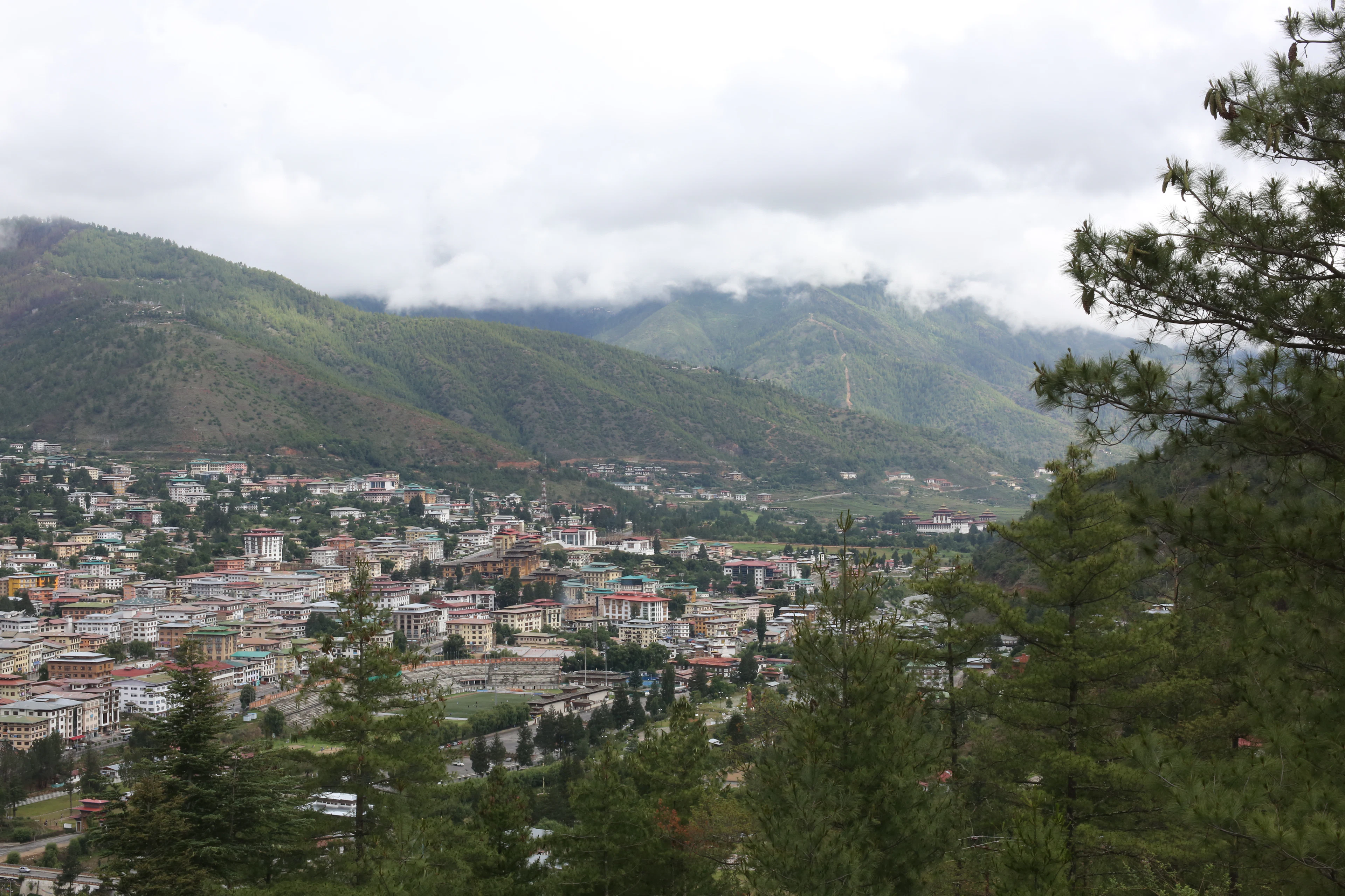 Green Himalayan hills under white clouds in Bhutan