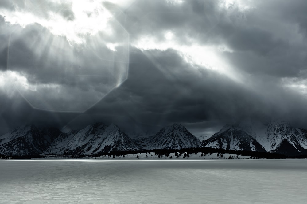 snow covered mountain near body of water during daytime