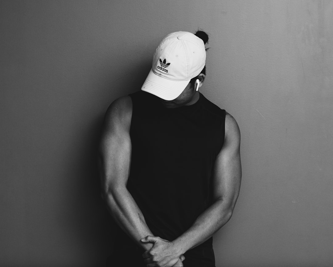 man in black tank top wearing white cap