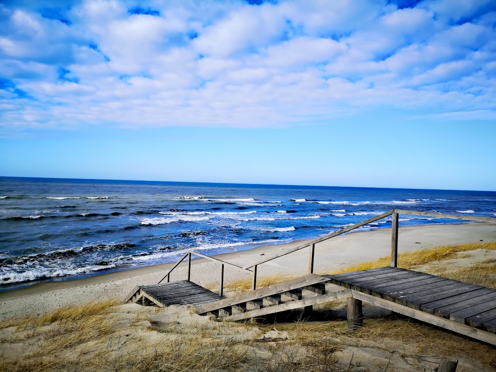 brown wooden dock on seashore during daytime