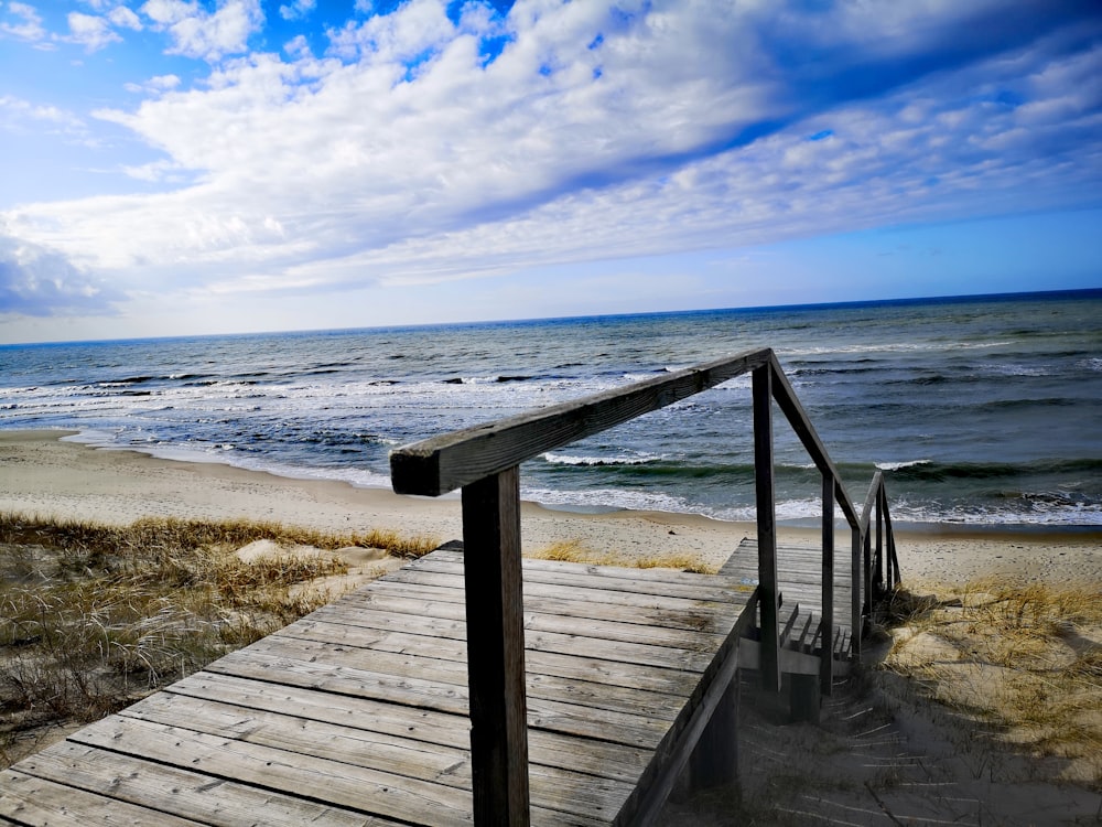 brown wooden dock on beach during daytime