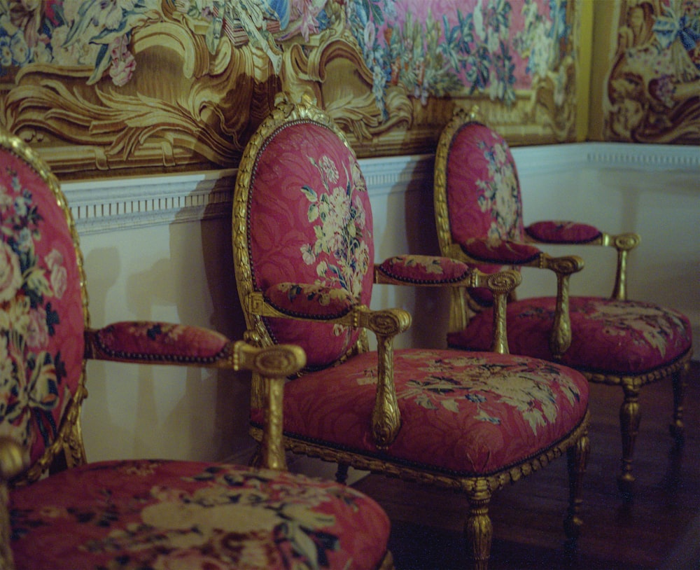 brown wooden framed red and brown floral padded armchair