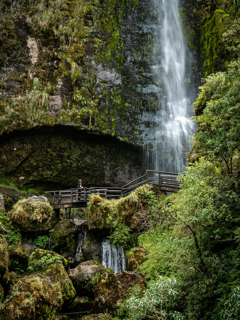 brown wooden bridge near waterfalls during daytime