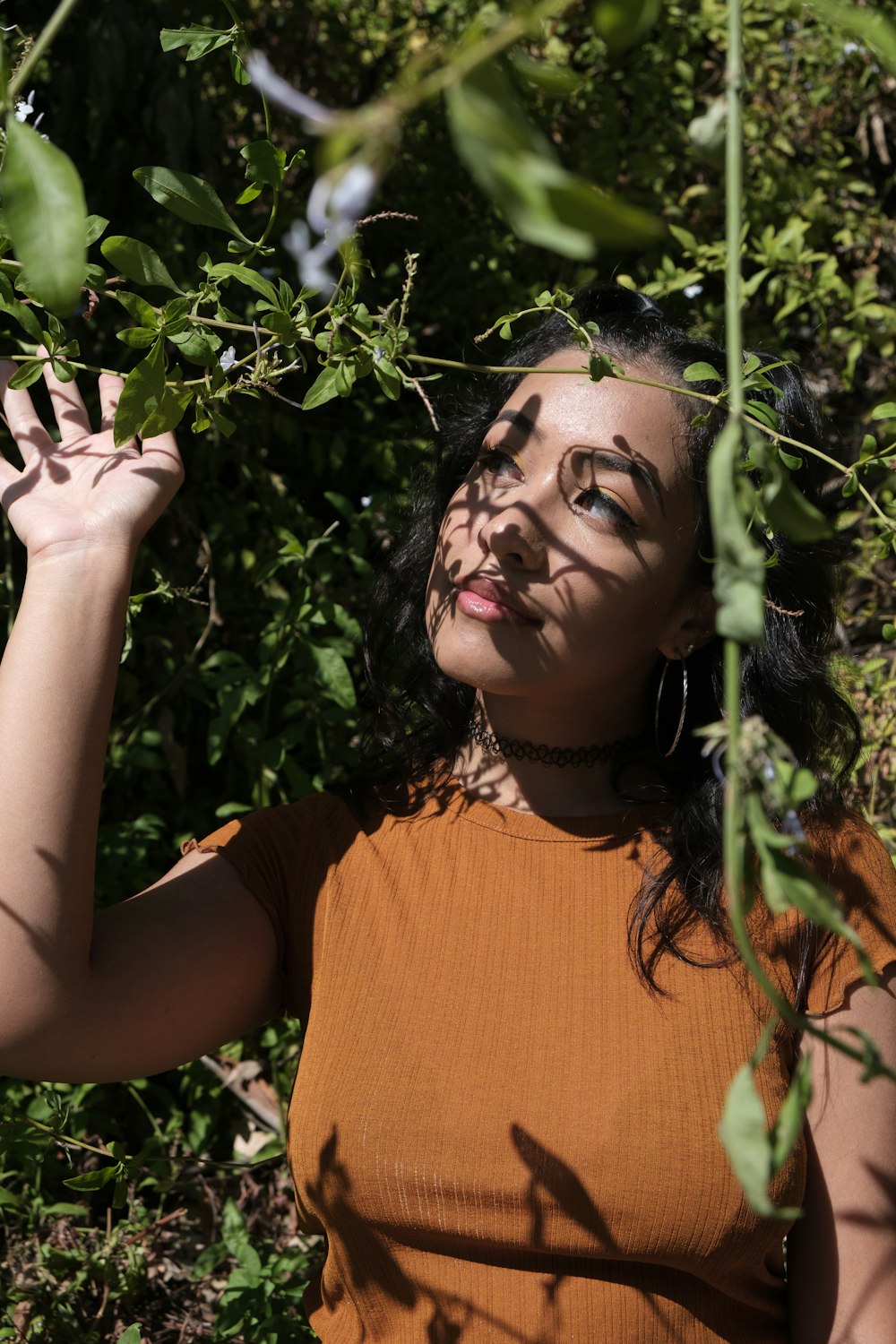 woman in orange crew neck t-shirt holding green plant