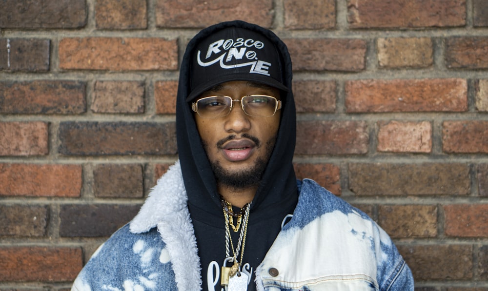 man in white zip up jacket wearing black cap