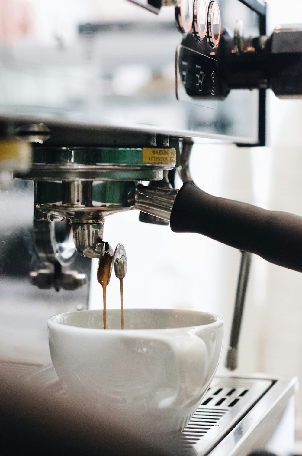 person pouring water on white ceramic cup