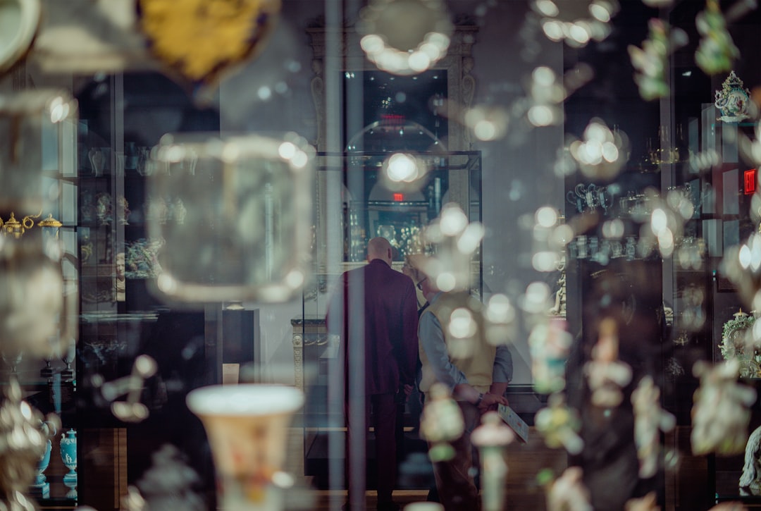 man in black coat standing near glass window
