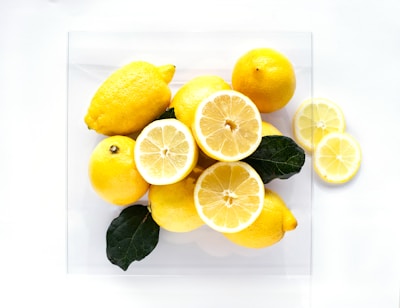 Fresh lemons sliced and arranged artistically on a white ceramic plate.