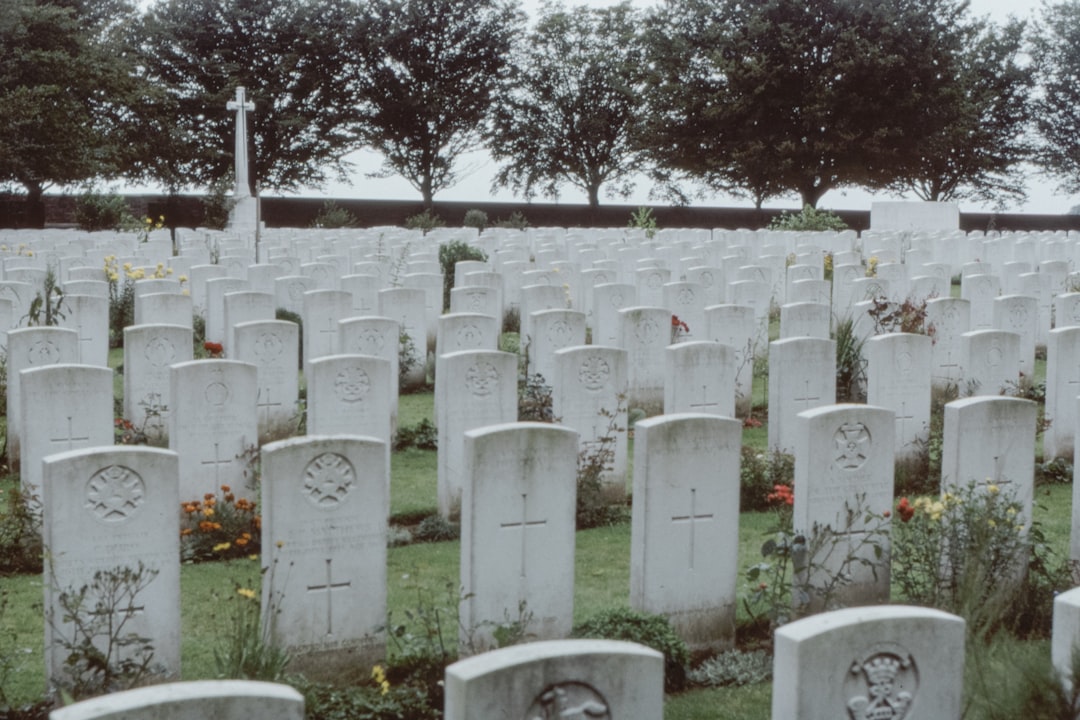 white cemetery with green trees during daytime