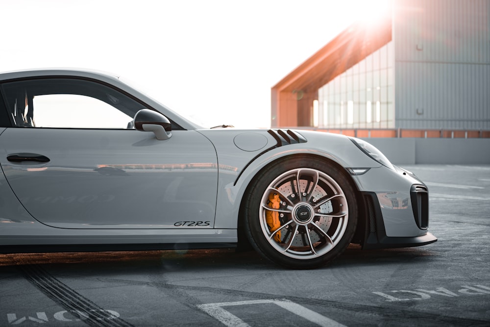 black porsche 911 parked in front of white building