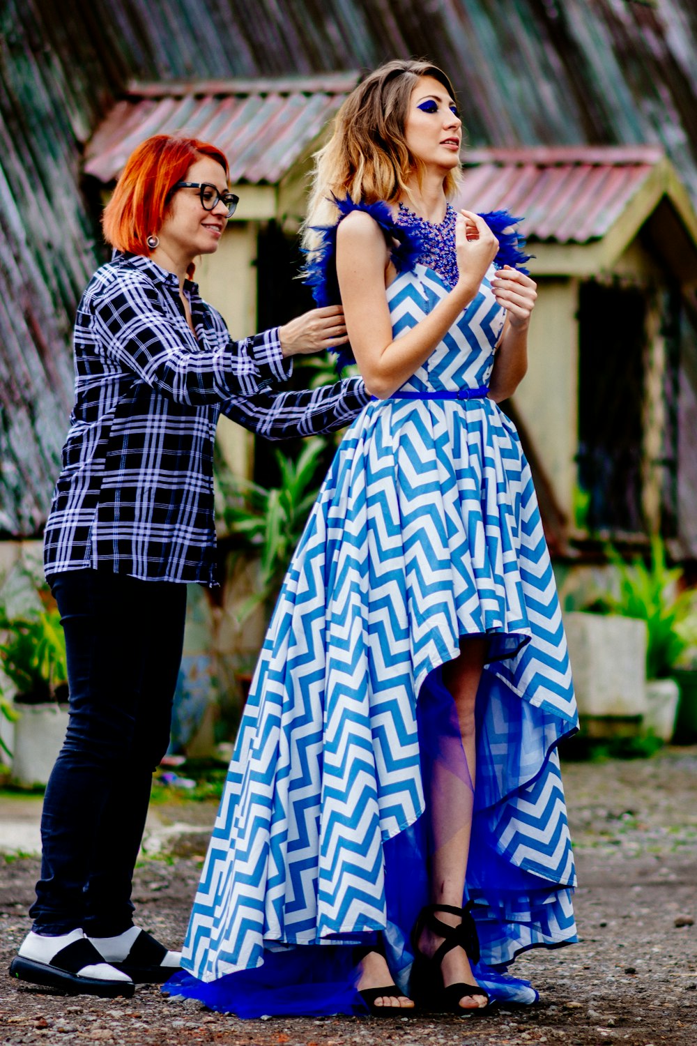 woman in blue and white dress standing beside man in black and white plaid dress shirt