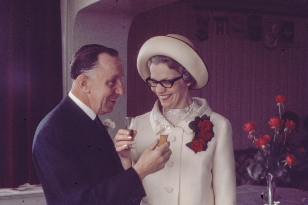 man in black suit jacket holding red rose bouquet