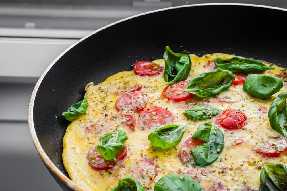 black frying pan with green vegetable