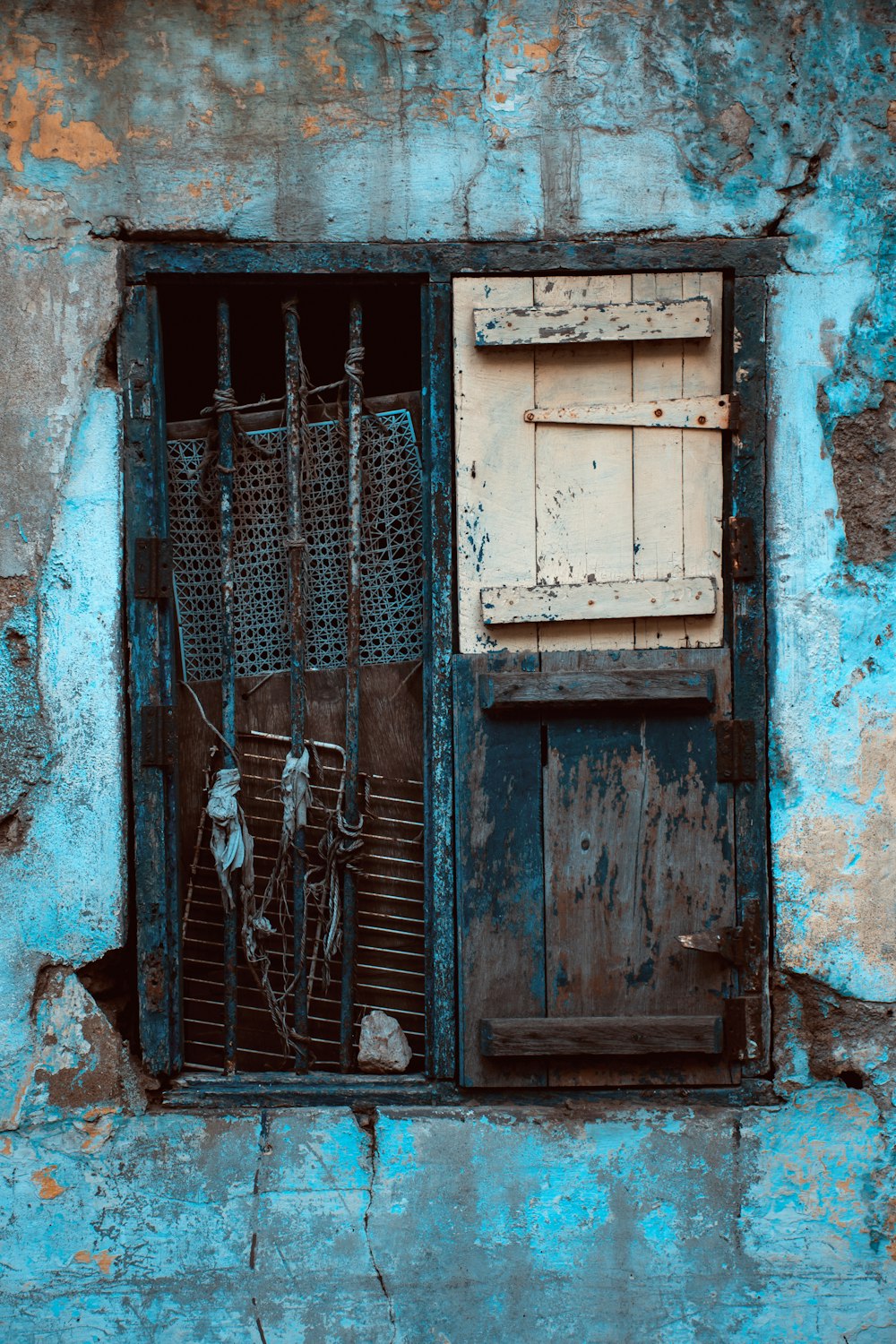blue wooden door with black metal window grill