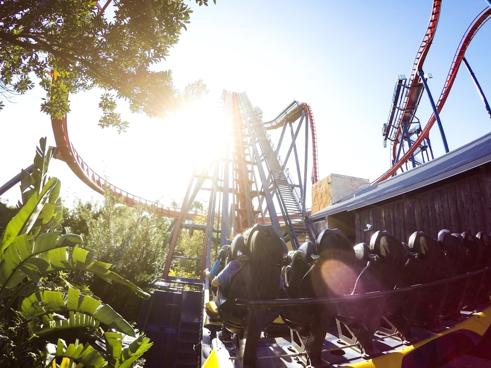 people riding roller coaster during daytime