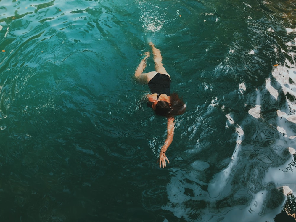 woman in black bikini swimming in water