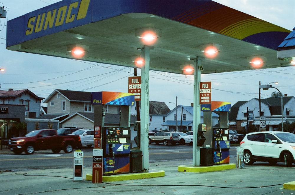 red car parked near blue and white gas station