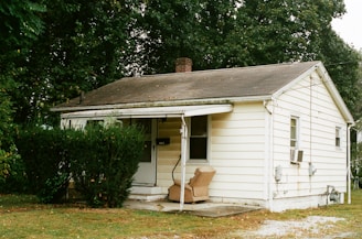 brown wooden stool near white wooden house