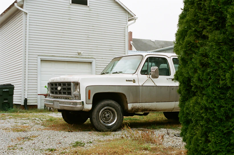 A clean, open driveway with a shiny truck from junkbreakup.com loaded neatly with removed household junk, ready for disposal.