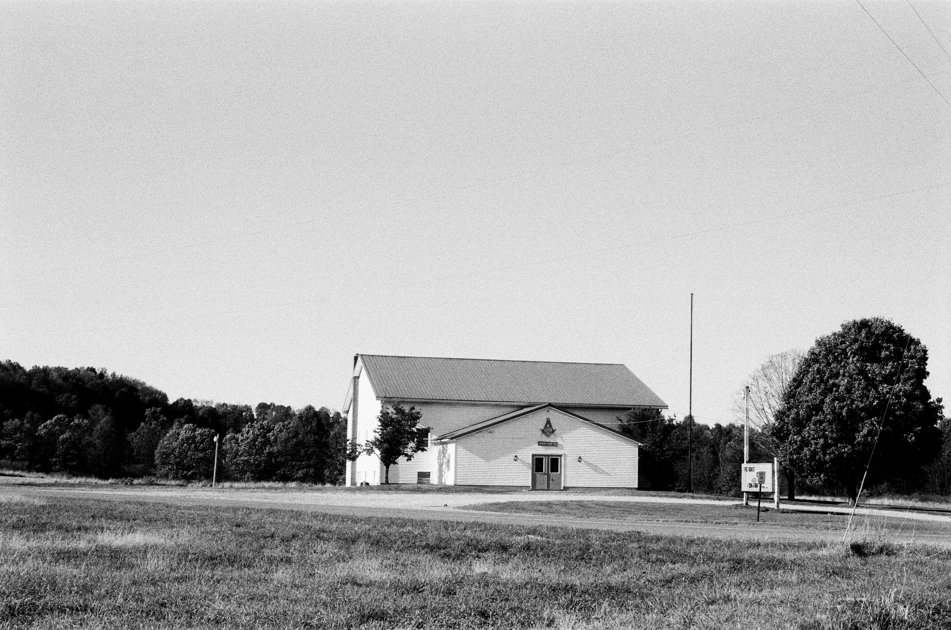 grayscale photo of house near trees