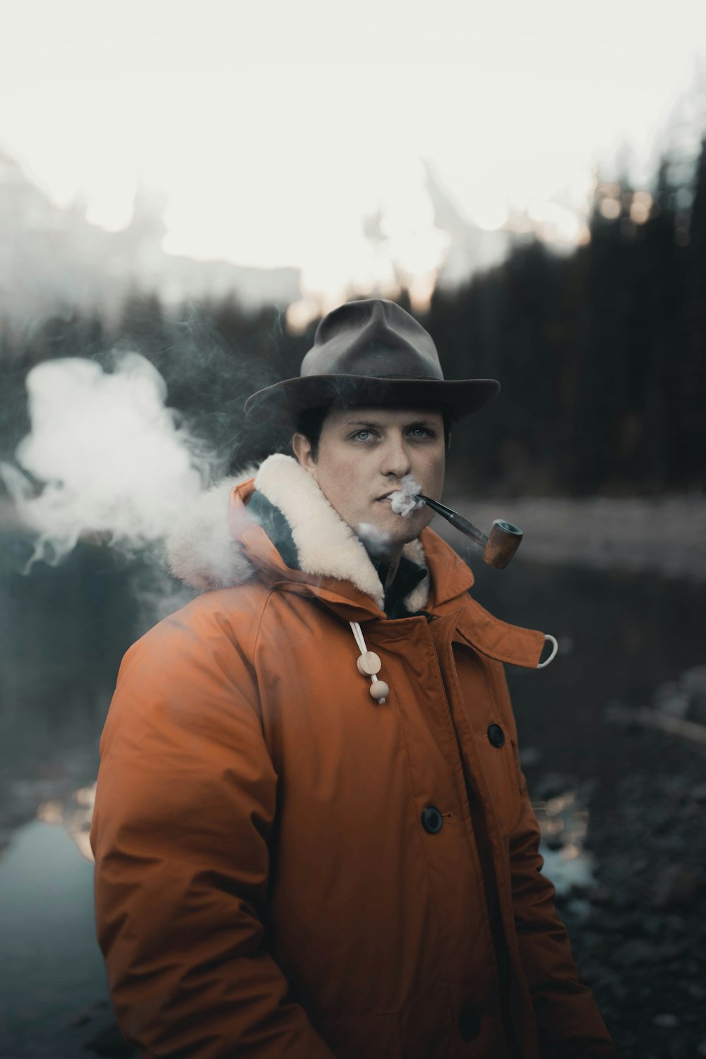 man in orange coat smoking cigarette