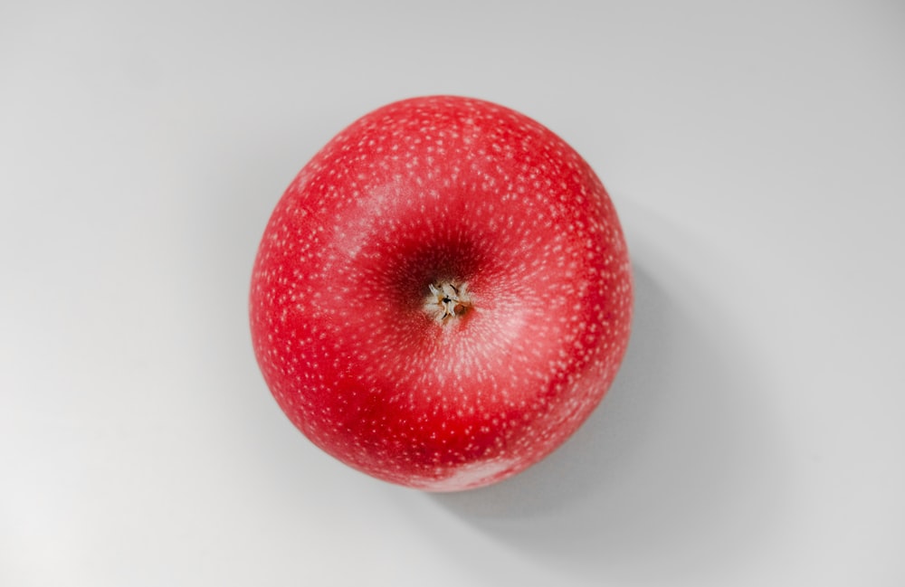 red apple fruit on white surface