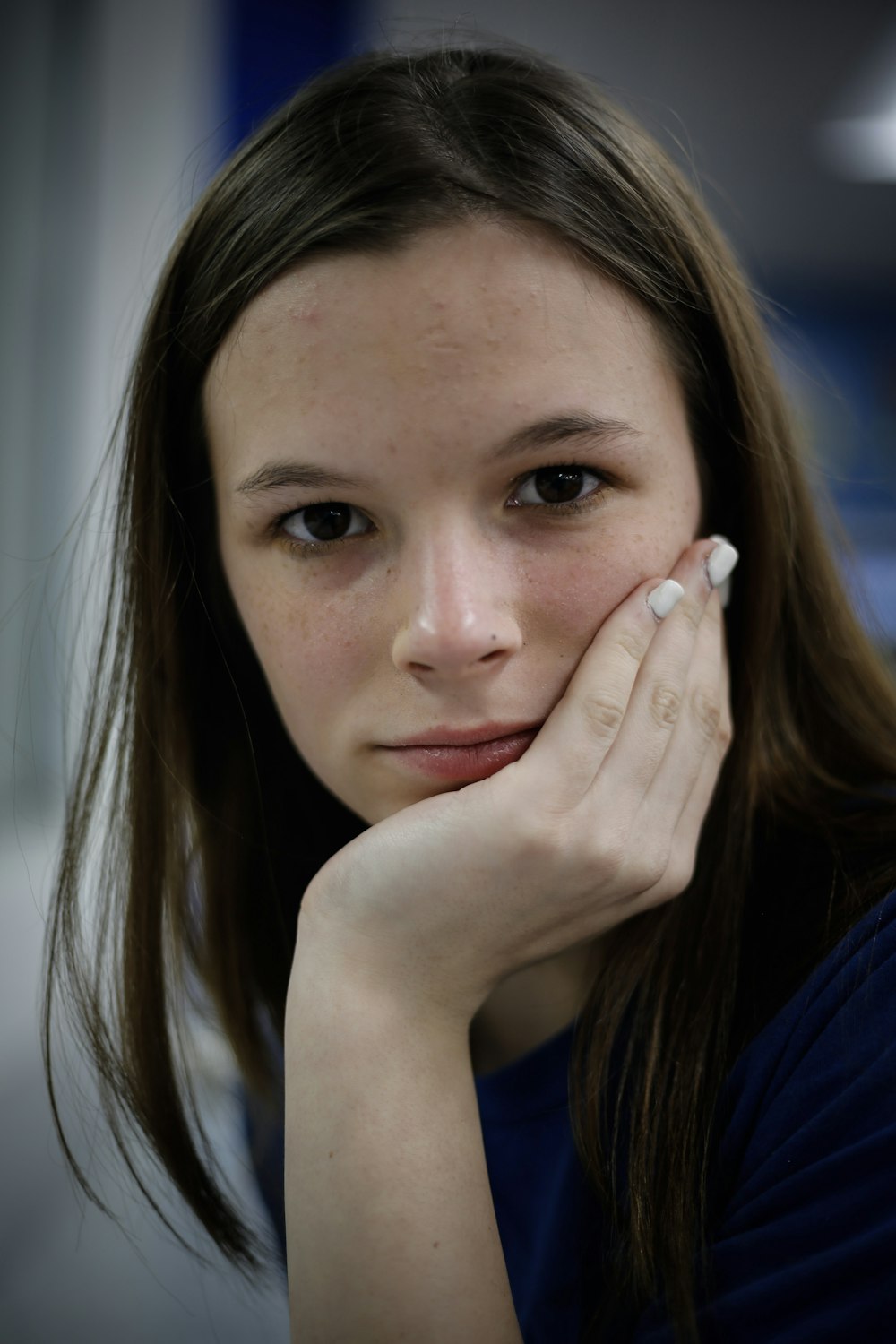 woman in blue shirt with white manicure