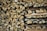 Stack of neatly arranged dry firewood logs ready for use in a rustic setting.