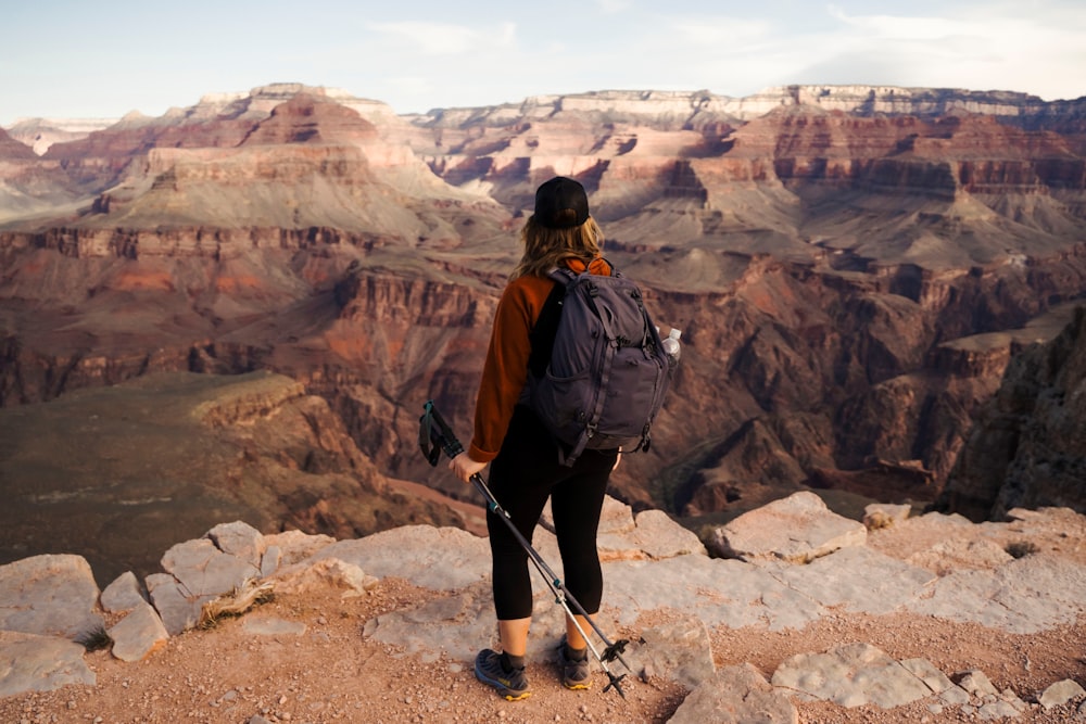 man in black jacket and black backpack standing on rocky ground during daytime