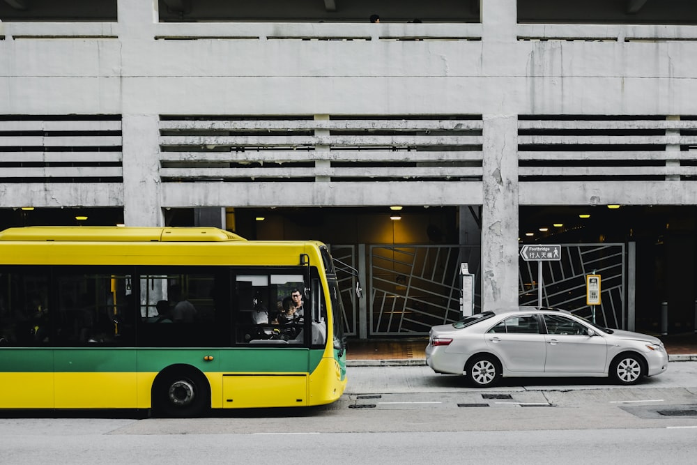 yellow and black bus on road near white building during daytime