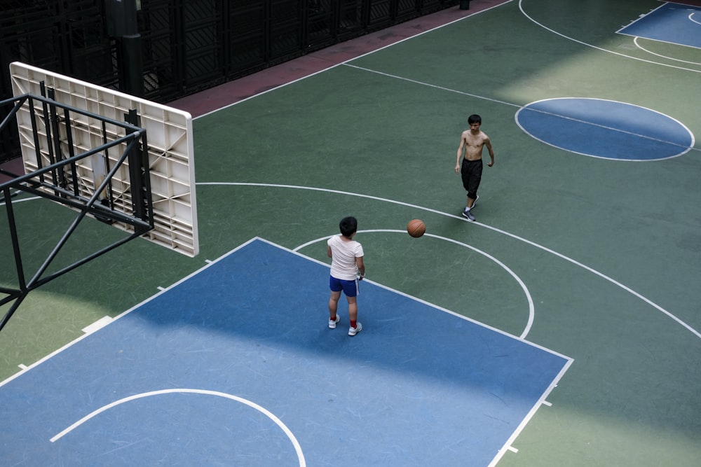 hombre con camiseta azul y blanca jugando al baloncesto